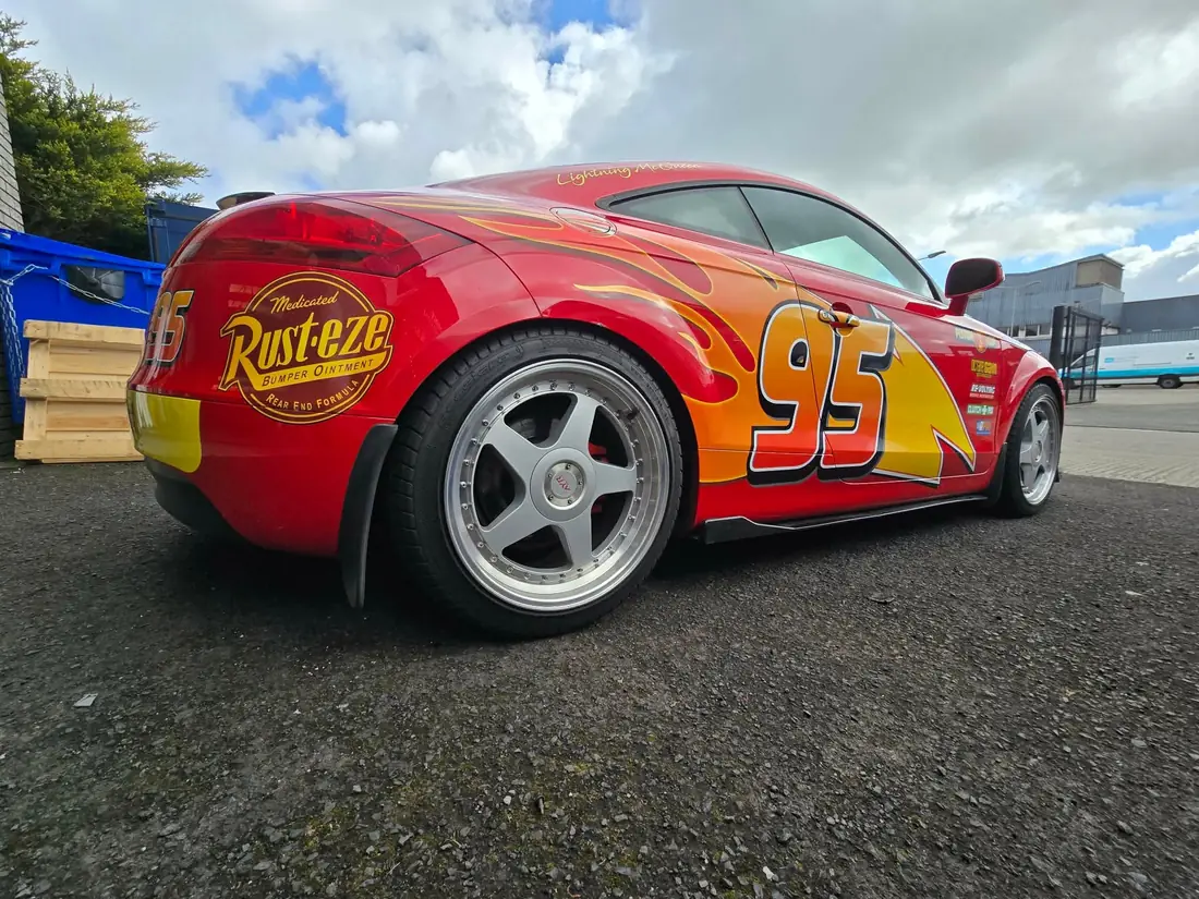 Low side view of the red race car showing its flame livery